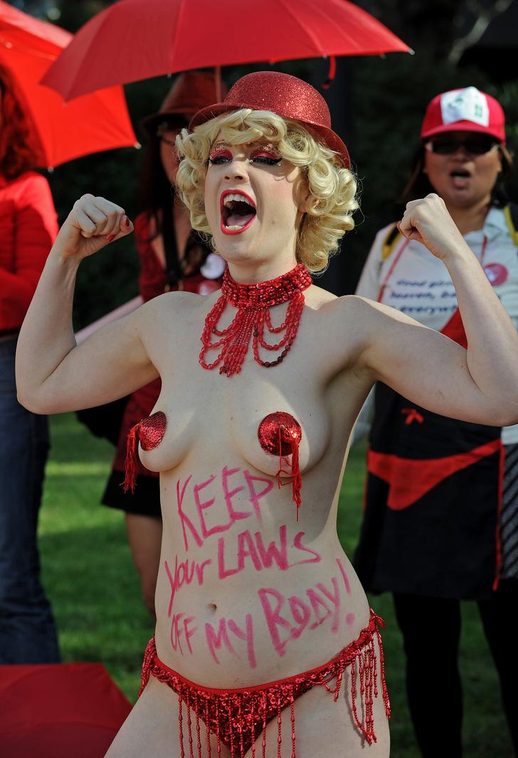 Секс работница Джинджер Снэп выступает во время акции протеста. Надпись на ее животе гласит - 