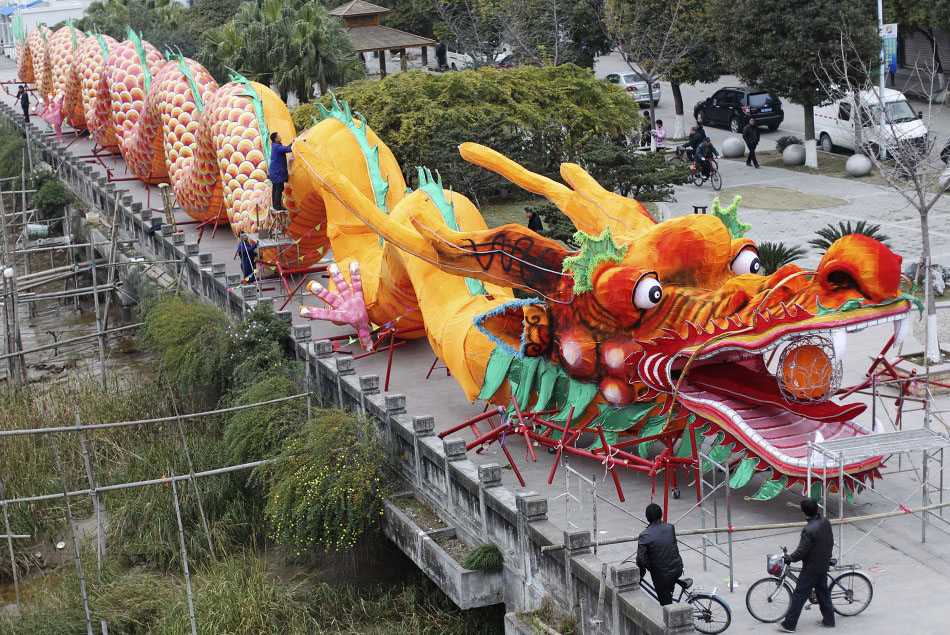 217625 workers decorate a dragon shaped sculpture ahead of the chinese new ye Подготовка к китайскому Новому году Дракона