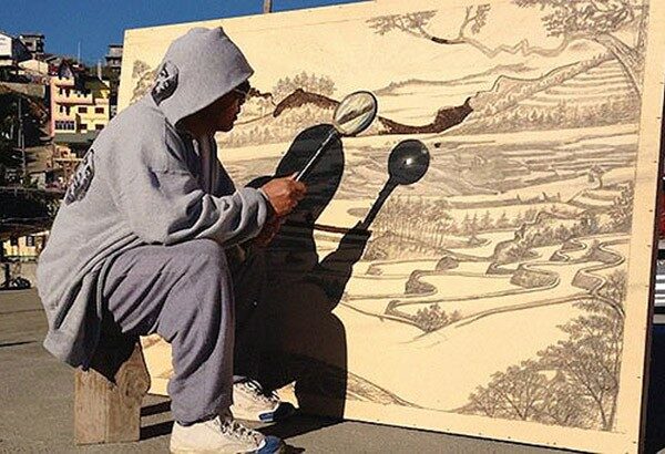 Художник рисует при помощи лупы и солнечного света