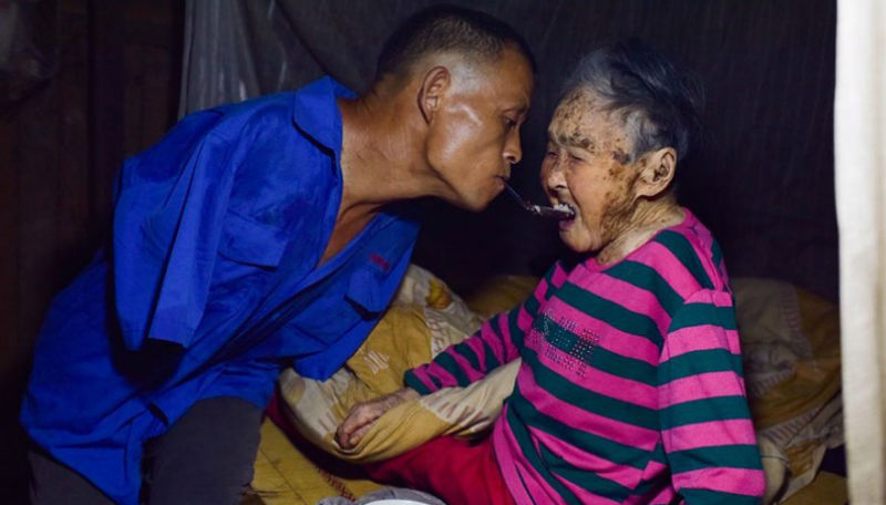 Фотография: Сын без рук кормит с ложечки свою парализованную мать — зубами №1 - BigPicture.ru