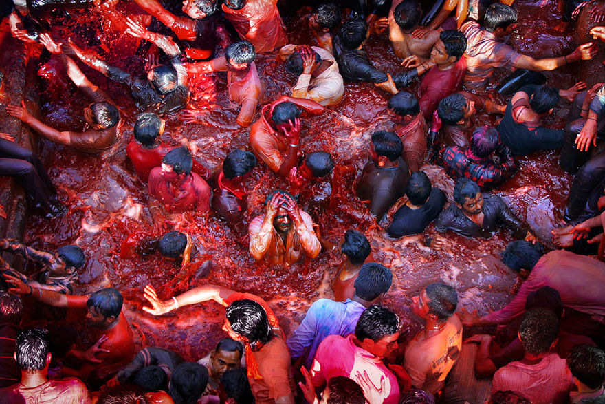 Индусы погружаются в водоем с краской во время празднования Холи в Насике, Индия