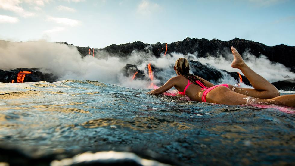 Элисон Тил гребет к извергающемуся вулкану Килауэа на Гавайских островах, США.