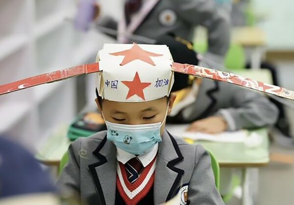 Китайские дети ходят в школу в смешных шляпах для социального дистанцирования