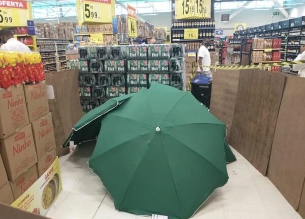 Когда сотрудник магазина умер, его прикрыли зонтами и продолжили работать