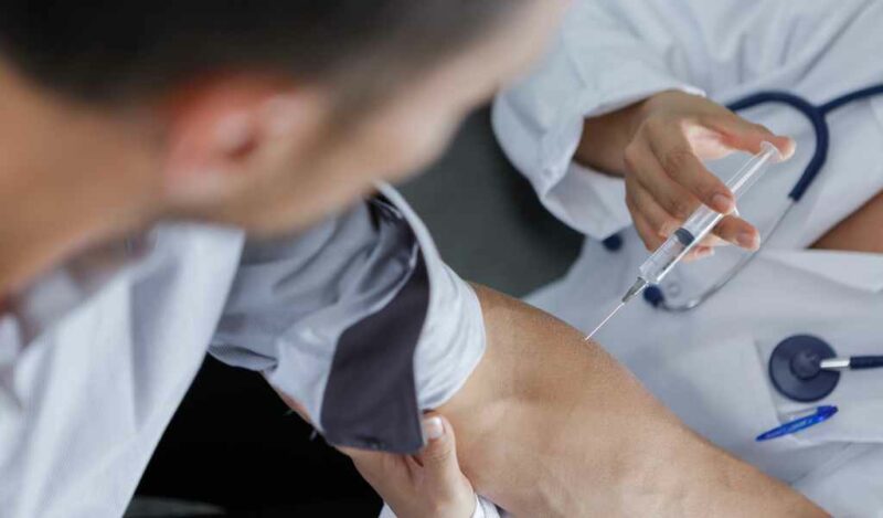 Doctor injection flu vaccine to patients arm