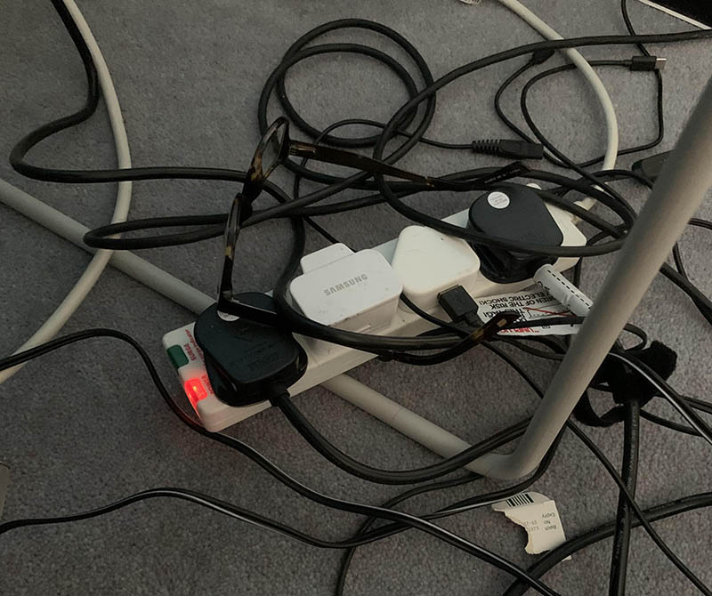 Очки лежат среди черных проводов их сложно найти маскировка