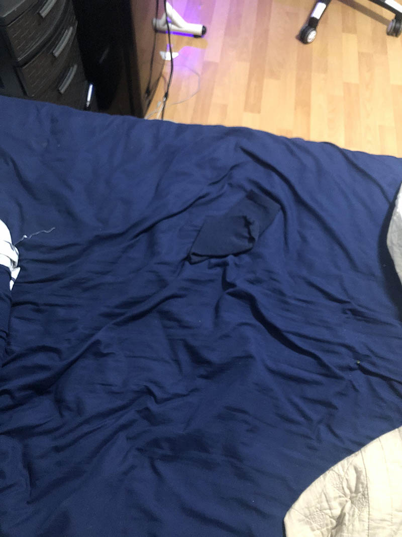 Синий носок лежит на синем покрывале не видно маскировка