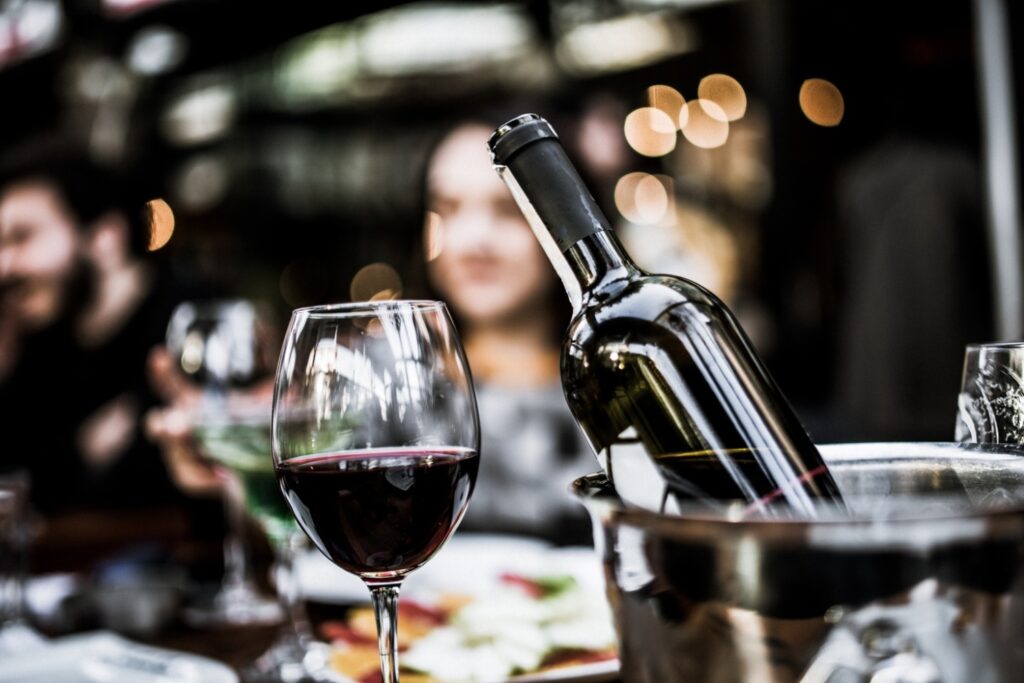 Red wine on open air restaurant cafe romantic joyful young adults table