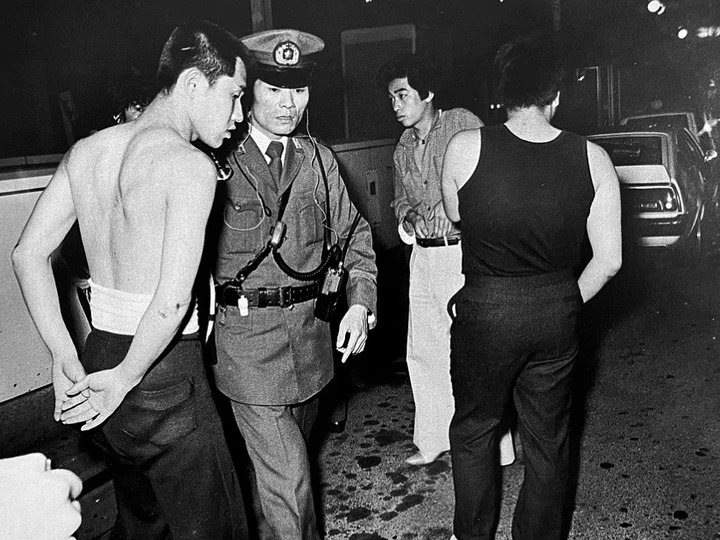 Полицейский с задержанными молодыми людьми на улице Токио 1970-е Flash Up