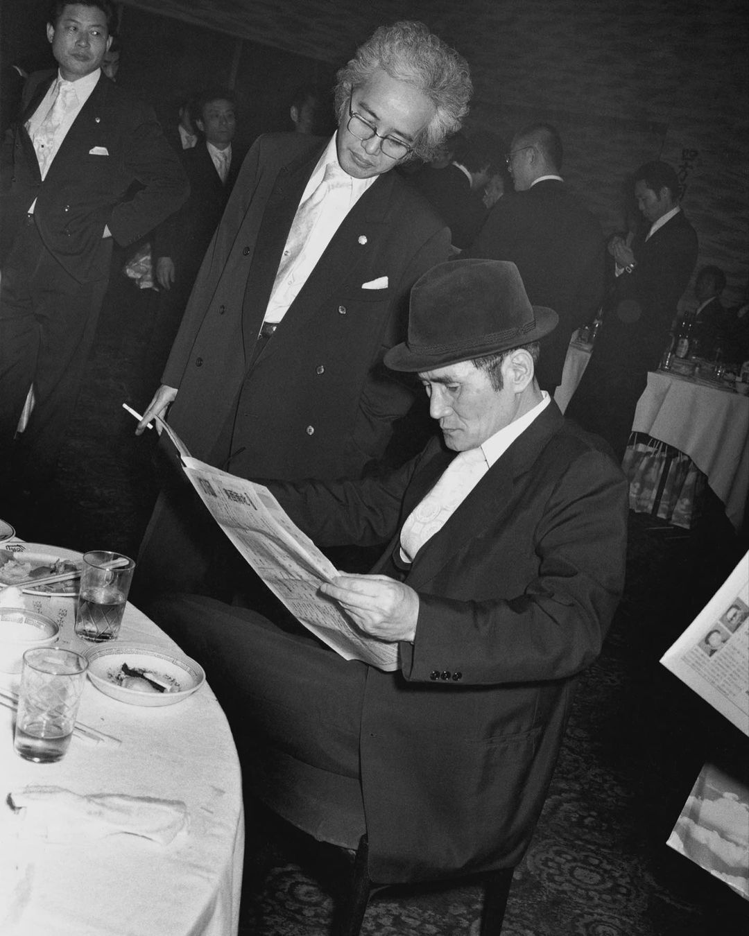 Мужчины читают газету в полутемном помещении документальная фотография Курата