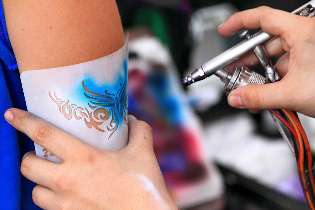Creating an air brush tatoo on a youn gilrs arm