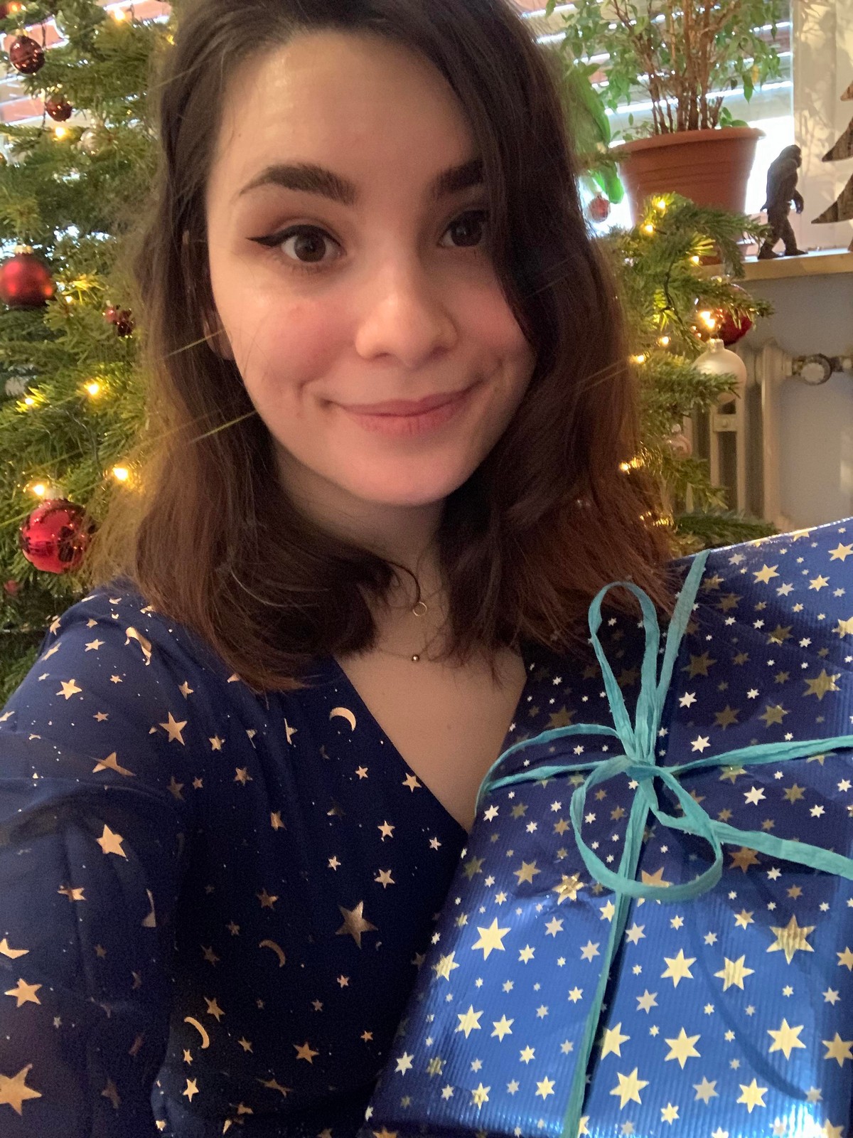 Девушка держит подарочную коробку с таким же узором как на пижаме совпадение