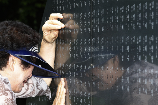 Bigpicture.ru Пожилая женщина скорбит возле обелиска с именами погибших