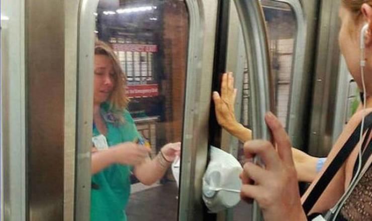 Женщина в зелёной футболке у закрытых дверей вагона метро с зажатой сумкой