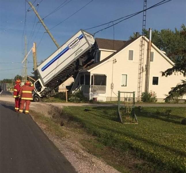 Грузовик врезался в стену жилого дома, рядом стоят пожарные