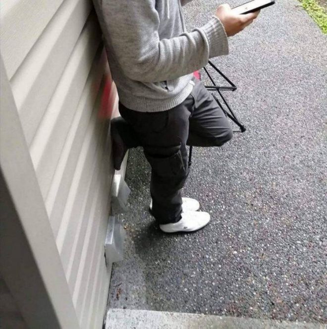 Человек в сером свитере сидит с необычно согнутыми ногами