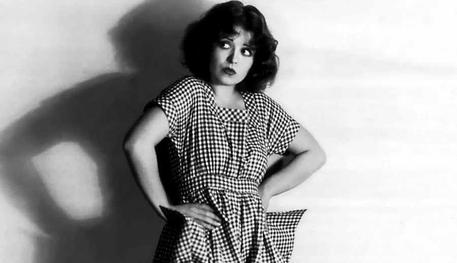 Клара Боу актриса немого кино в платье в клетку с руками на бёдрах