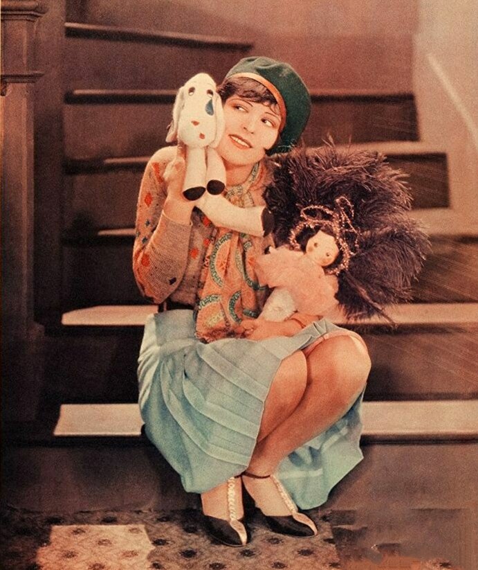 Клара Боу секс-символ Голливуда сидит на ступеньках с плюшевой игрушкой