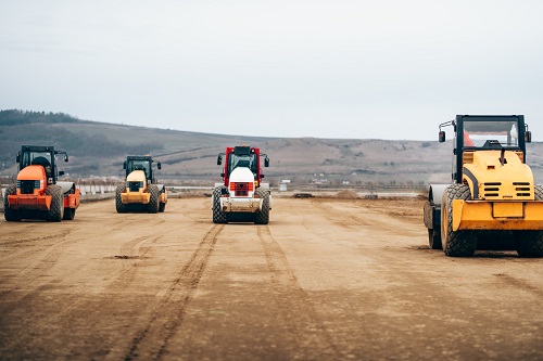 Vibratory compactor during road and highway construction. industrial roadworks with heavy duty machinery