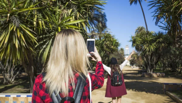 Back view women taking photos park 600x339