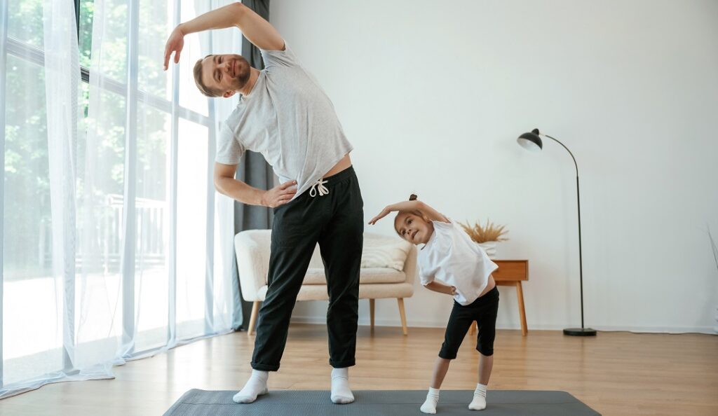 Мужчина и маленькая девочка делают зарядку