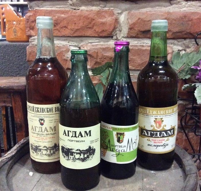 Бутылки советских портвейнов 777 и Агдам на деревянном столе