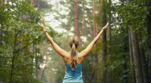 Девушка в лесу стоит раскинув руки