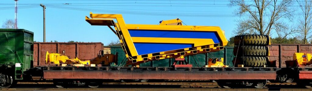 Logistics transportation heavy mining dump truck by rail. yellow