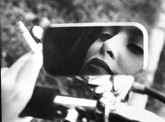 Девушка отражается в зеркале мотоцикла, кадр Ришара Ожара