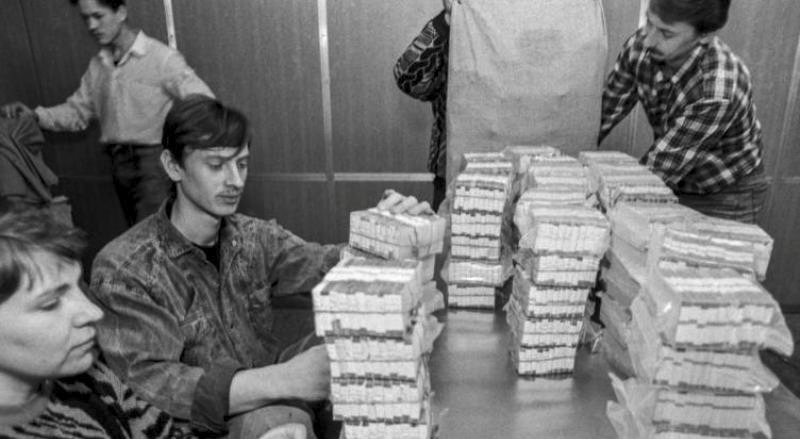 Люди складывают пачки денег
