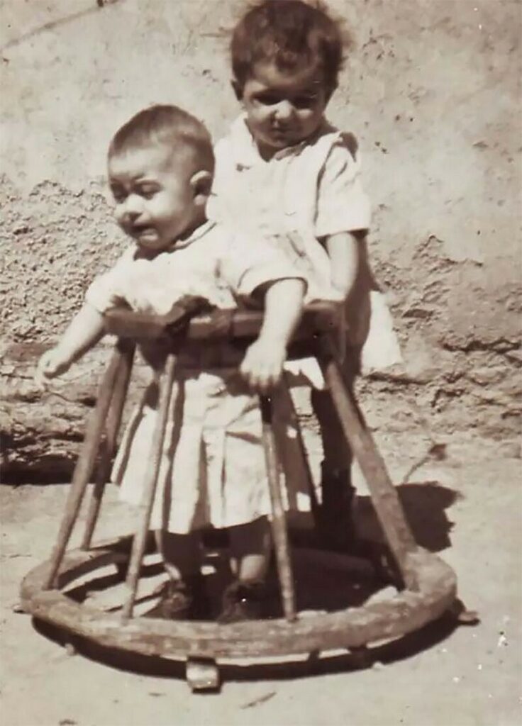 Ретрофото двое детей один с деревянными ходунками