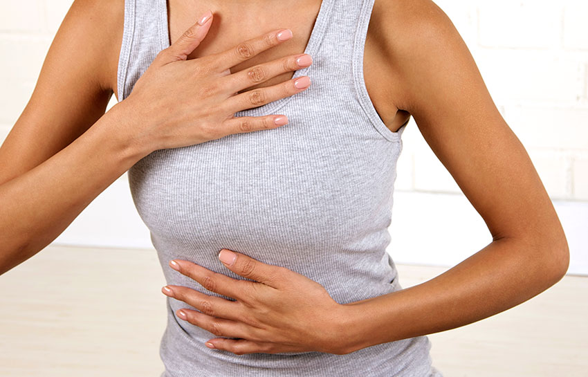 Женщина выполняет диафрагмальное дыхание животом, рука лежит на животе