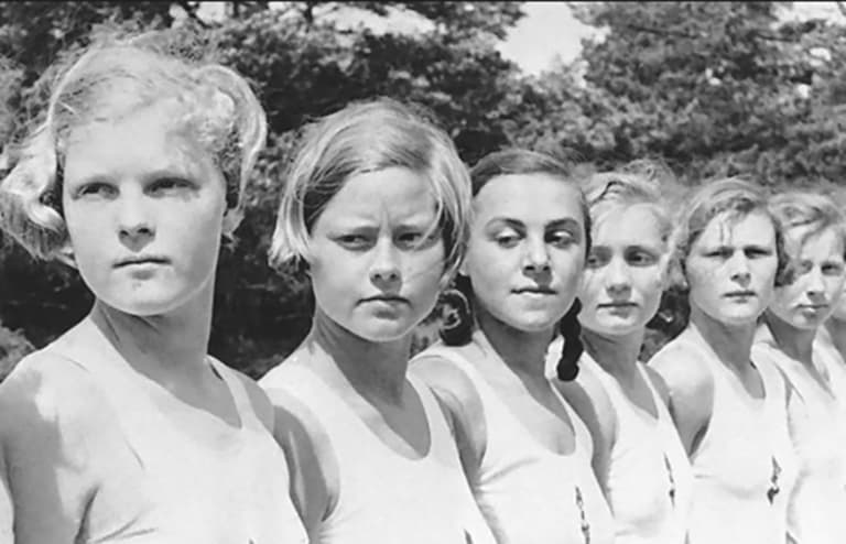 Дети в форменной одежде стоят в ряд в приюте Лебенсборн 1940-е годы