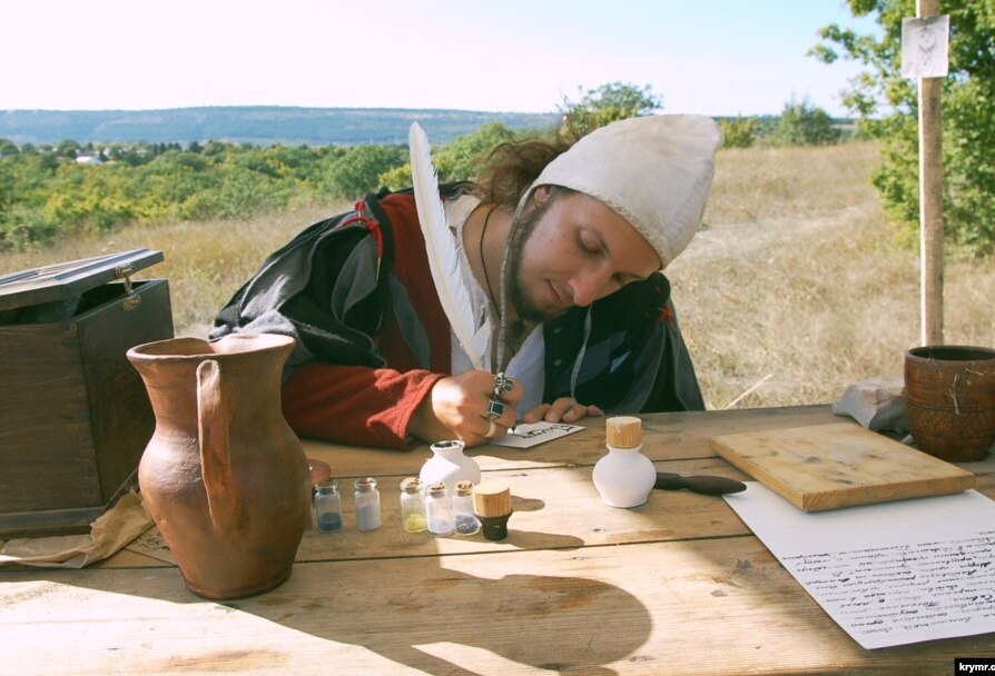 Средневековый писец пишет гусиным пером, стараясь не отрывать его от пергамента