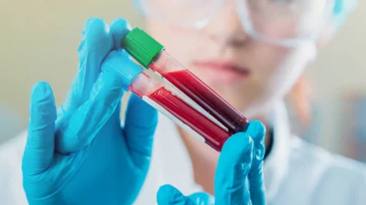 Медработник держит две пробирки с кровью 