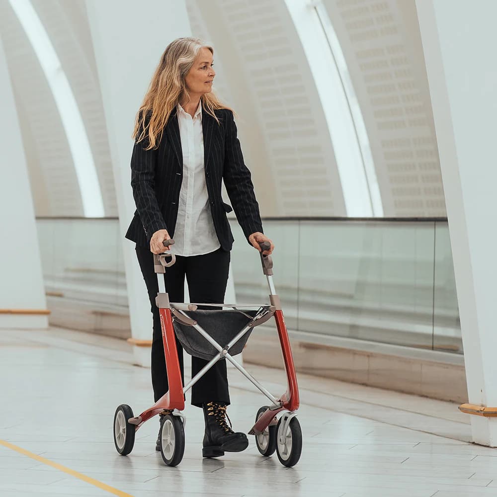 Пожилая женщина идёт с ходунками в аэропорту