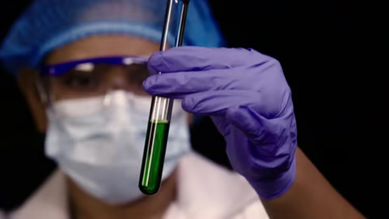 Зелёная кровь в медицинской пробирке рядом с красной