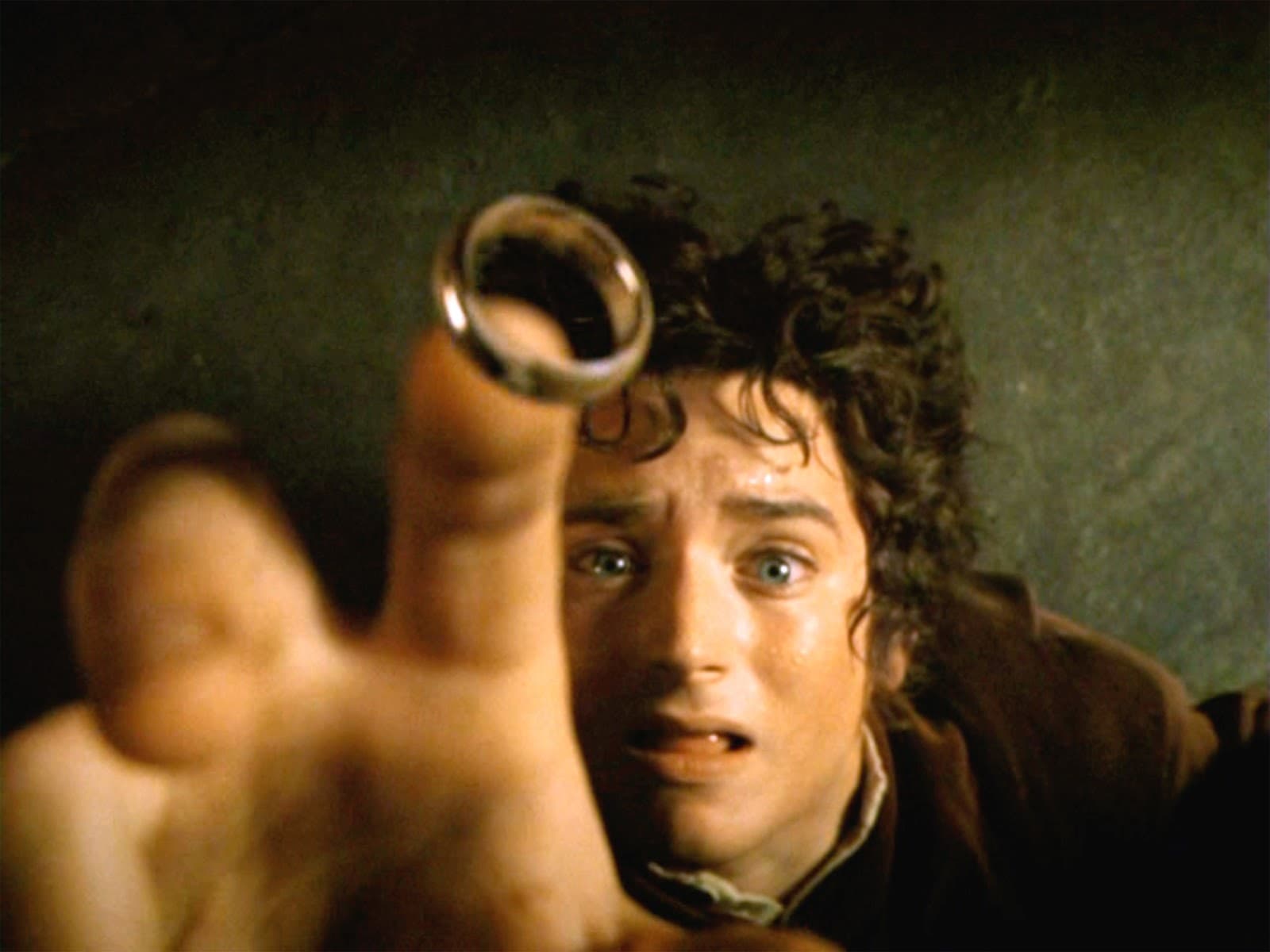 Хоббит Фродо Бэггинс в исполнении Элайджи Вуда с Кольцом Всевластия в таверне Гарцующий пони