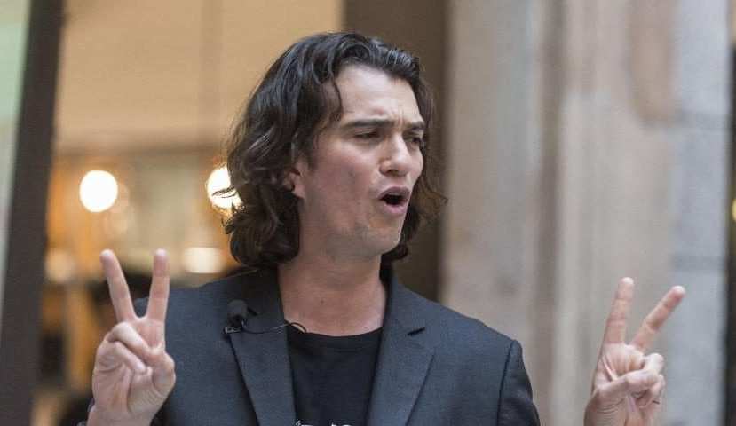 Кадр с Адамом Нейманом (Adam Neumann), показывающим жесты руками на сцене