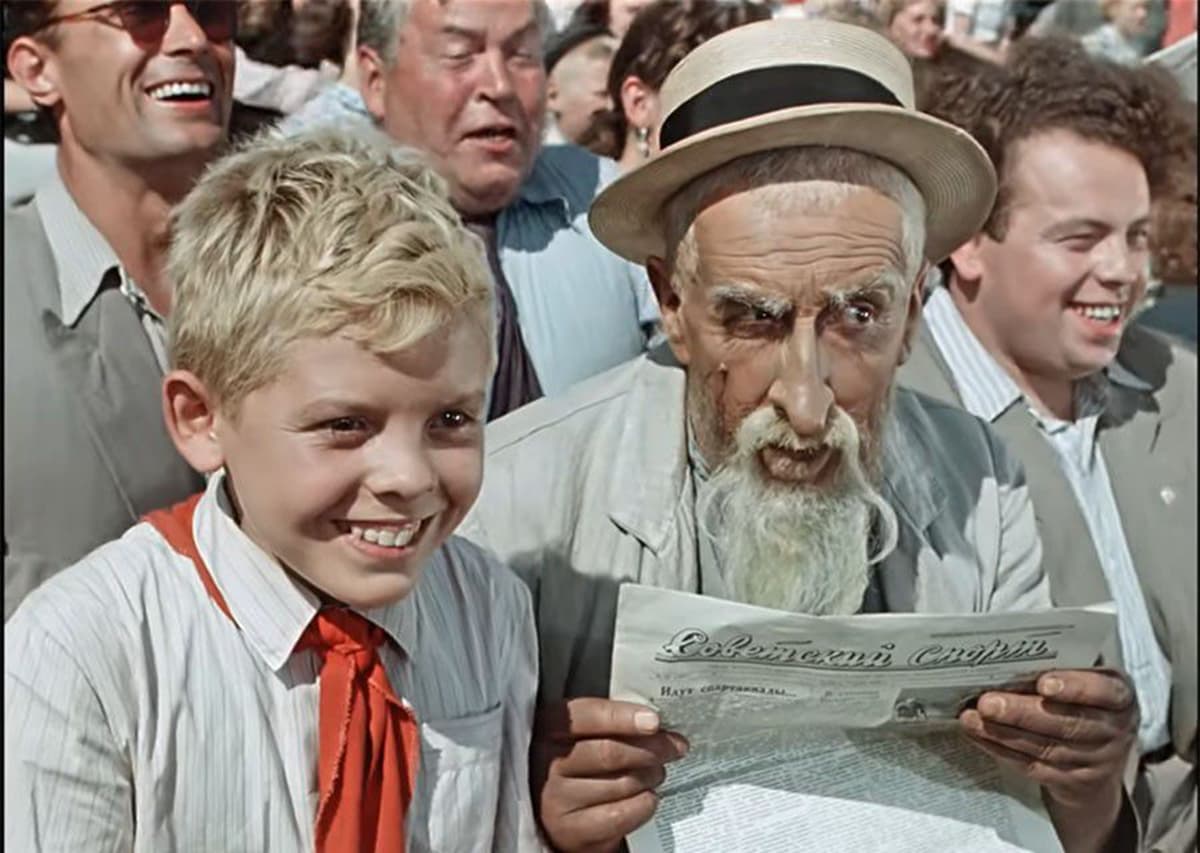 Кадр из фильма Старик Хоттабыч с Волькой и джинном на фоне толпы