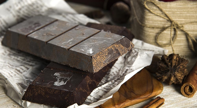 Плитка темного шоколада с белым налетом поседением на поверхности