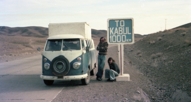 Фотография длинной дороги и автобуса с хиппи где-то в иранской пустыне