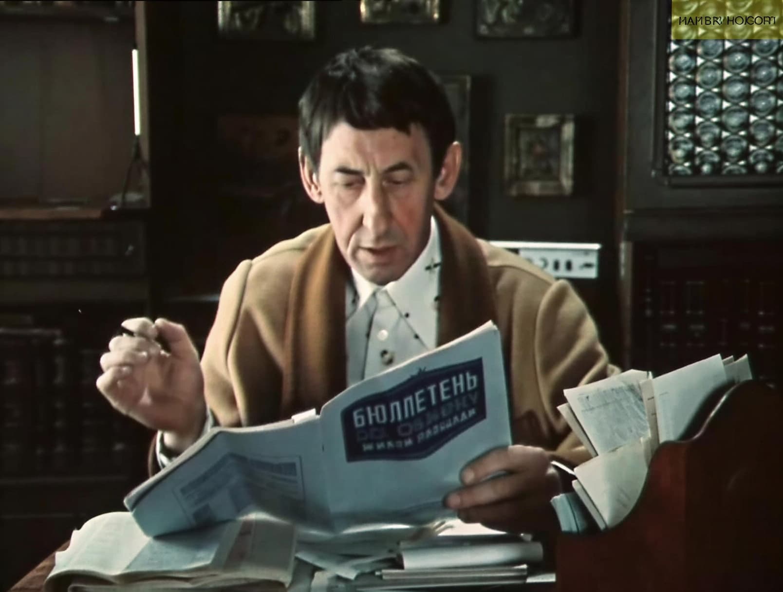 Маклер изучает бюллетень по обмену жилья &mdash; кадр из советского фильма