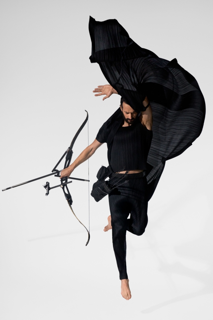 Лучник с луком в прыжке левитация в фотографии черная ткань Матье Форже