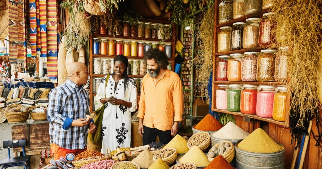 Современный магазин специй: покупатели выбирают пряности, разноцветные горки специй на прилавке