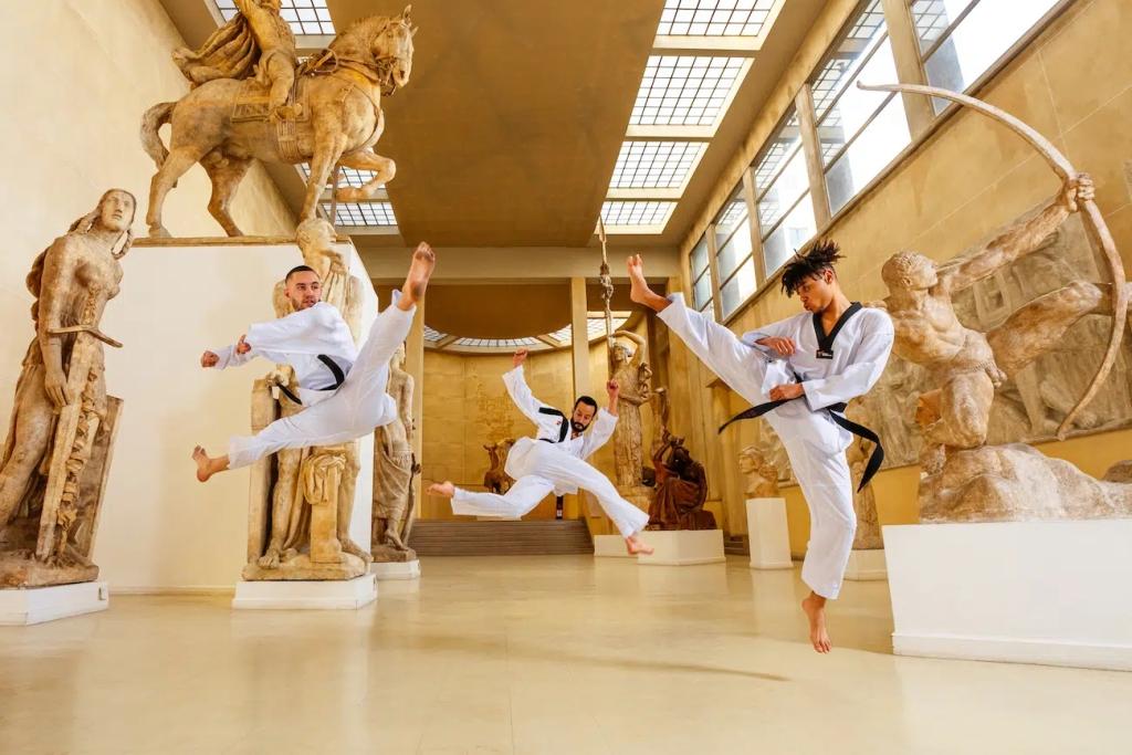 Каратисты в кимоно высокий удар ногой фотография боевых искусств левитация музей