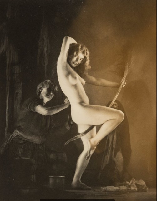 Обнаженная ведьма танцует на шабаше с метлой в руках среди мрачных фигур &mdash; динамичная жуткая композиция Уильяма Мортенсена