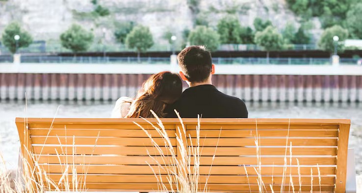 Влюбленная пара сидит на скамейке