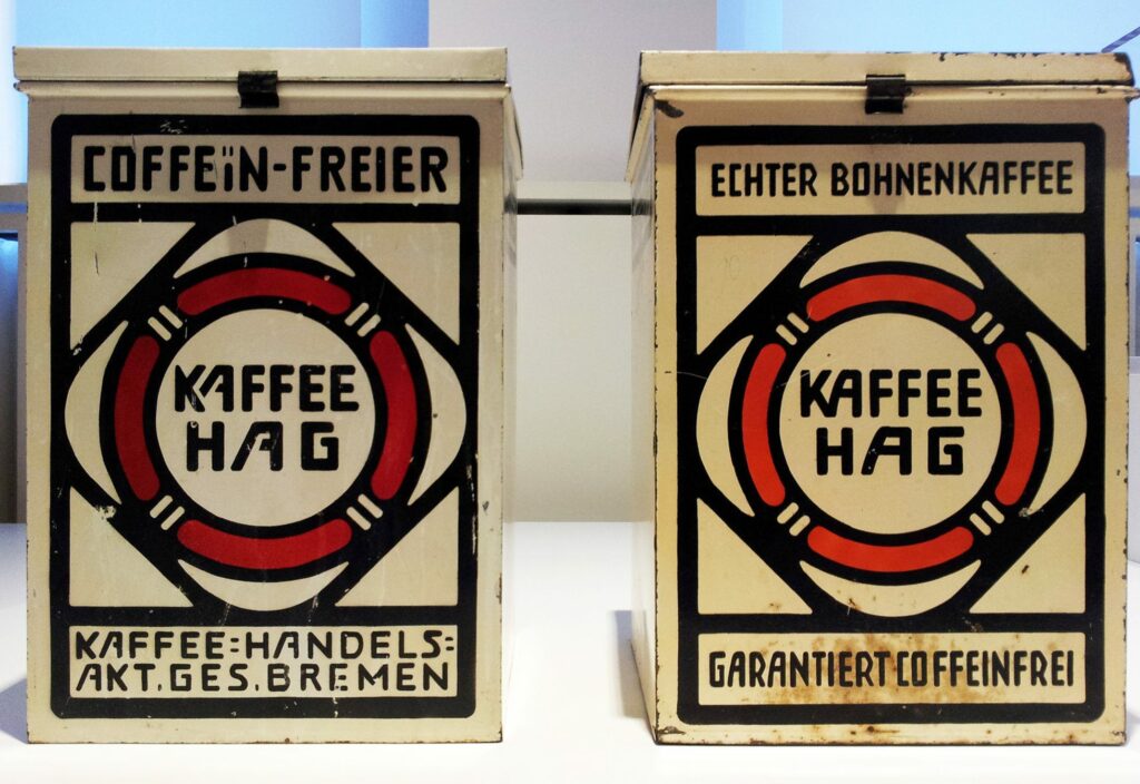 Стеклянная витрина в музее: на полках выставлены жестяные банки Kaffee HAG разных лет и дизайнов.