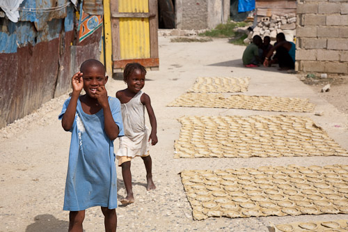 Дети проходят мимо сушащегося на солнце глиняного печенья